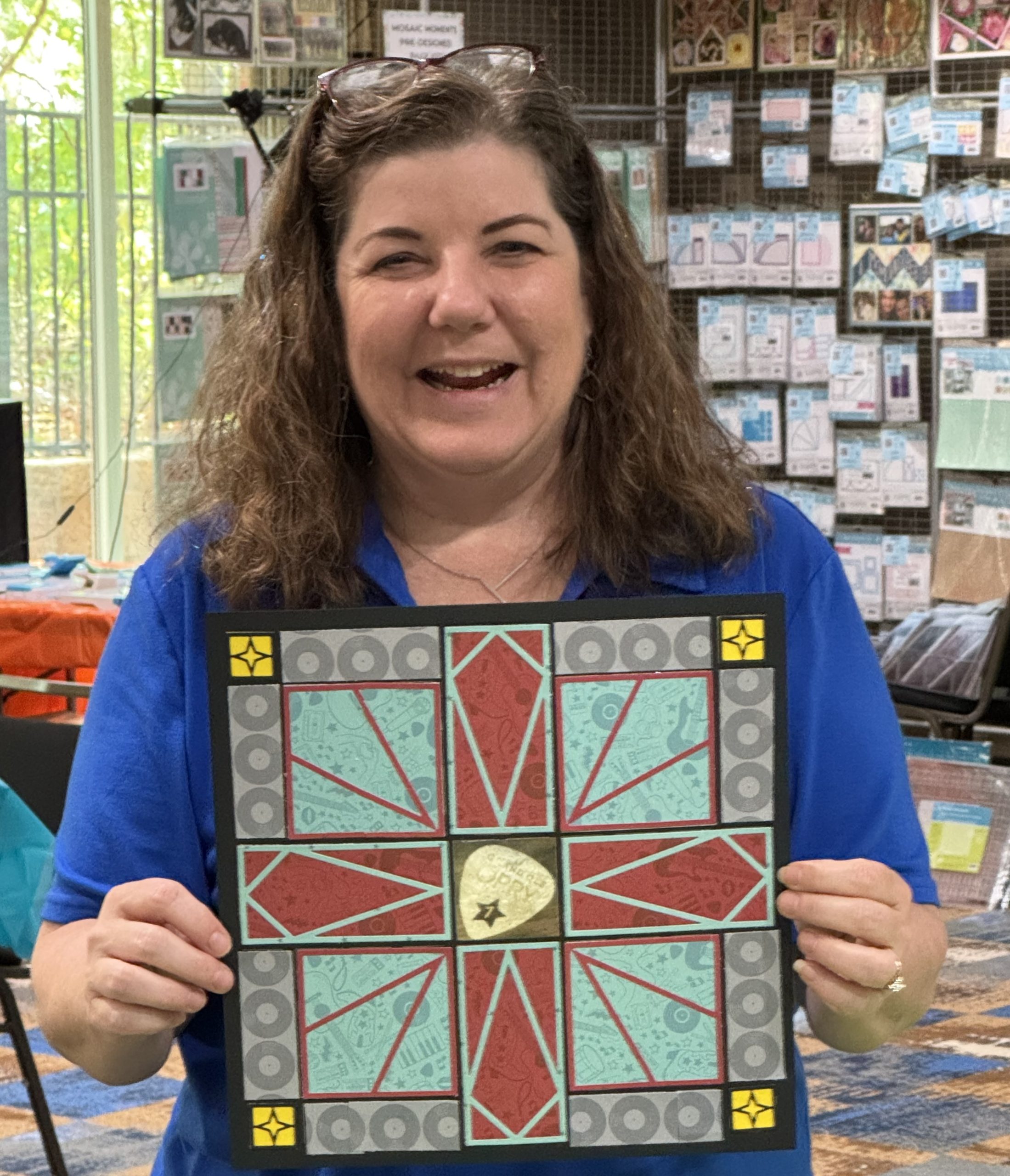 Tara holding a completed scrapbook layout