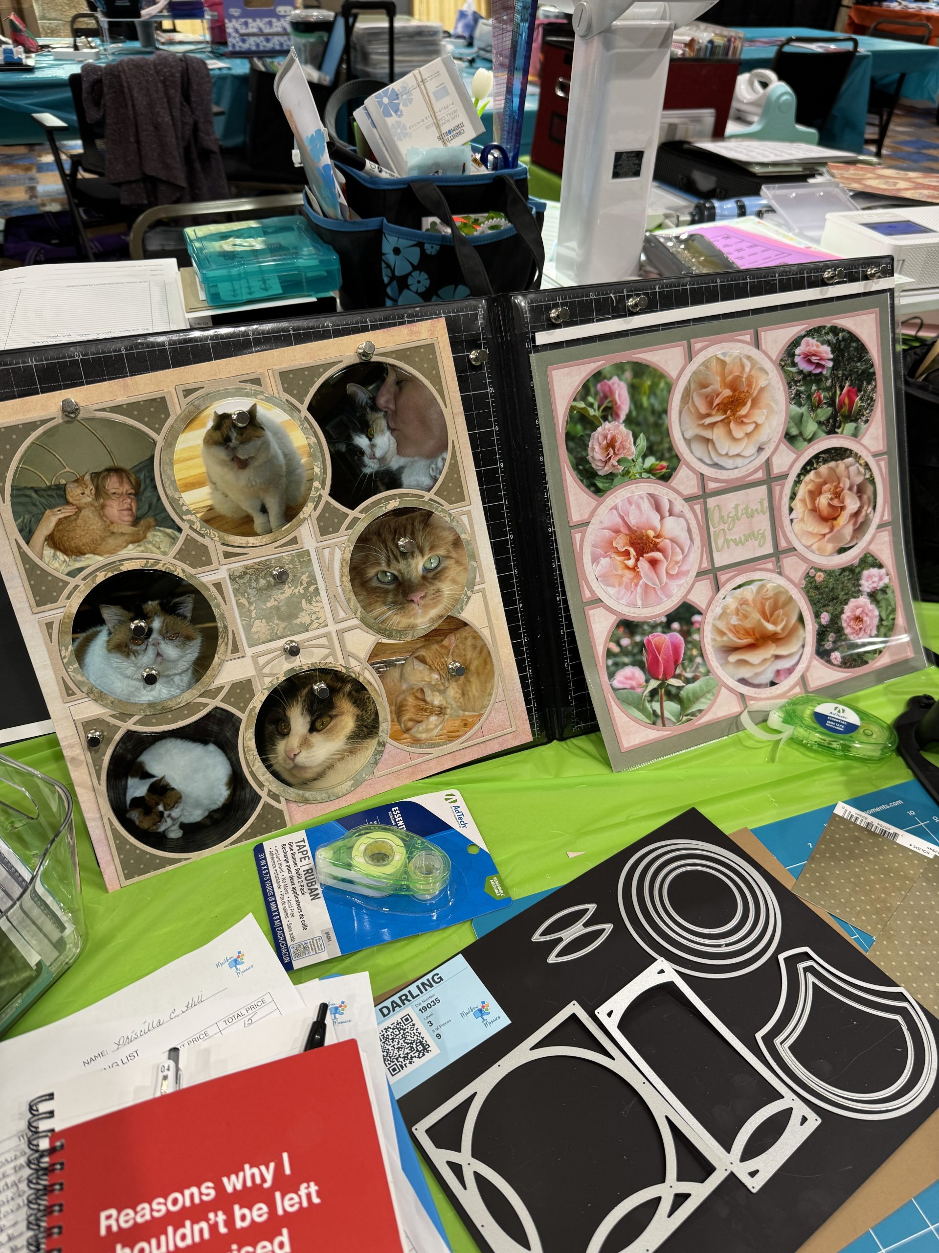Cat and flower scrapbook layouts displayed at a creative event