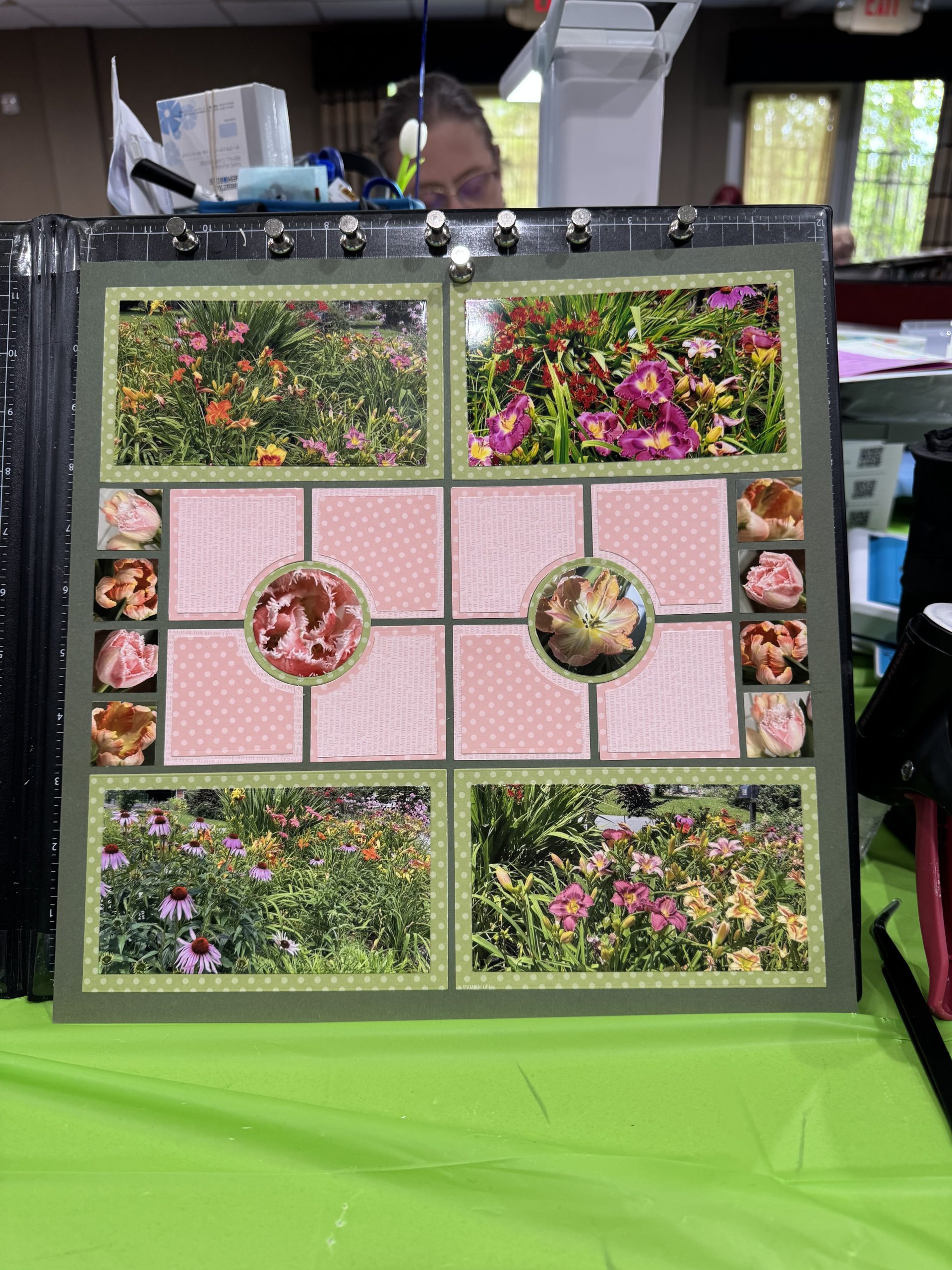 A scrapbooker displaying a colorful floral grid layout